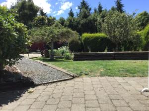 a garden with a brick walkway and a lawn at Self contained and private room in Dunedin +5 photos