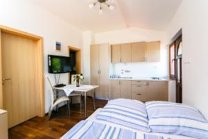 a bedroom with a bed and a table and a kitchen at Apartments Josip in Pinezici