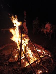 a person standing next to a bonfire at night at Sneha Farm House in Kudāl