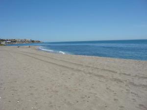 a sandy beach with the ocean in the background at Balcon Del Mar Primera Linea de Playa in La Cala de Mijas