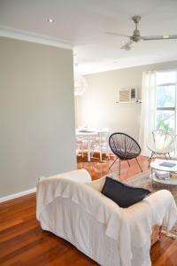 a living room with a white couch and a table at Gregory's Place Short Term Rental Western Sydney in Colyton