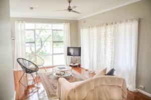 a living room with a couch and a window at Gregory's Place Short Term Rental Western Sydney in Colyton