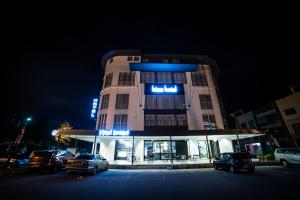 a building with cars parked in front of it at night at bizz hotel in Puchong