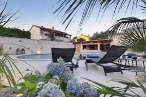 un patio con 2 sedie e una piscina di Villa Sonja a Medulin