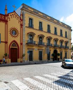 ヘレス・デ・ラ・フロンテーラにあるItaca Jerez by Soho Boutiqueの正面に車を停めた路上の建物