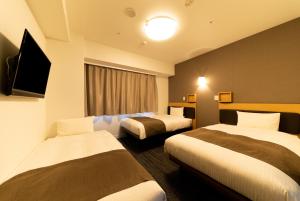 um quarto de hotel com duas camas e uma janela em Pearl Hotel Shinjuku Akebonobashi em Tóquio