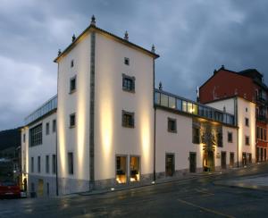a large white building on the side of a street at Hotel Palacio de Merás in Tineo