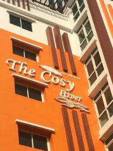 バンコクにあるThe Cosy Riverの十字架の看板を持つオレンジ色の建物
