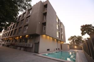 a building with a swimming pool in front of a building at Kukda Resort Chittorgarh in Chittaurgarh