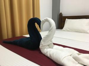 Dos cisnes haciendo un corazón en una cama en Hotel Lovusiyah en Jaffna