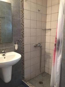 a bathroom with a sink and a shower at Zathea Apartments in Agia Pelagia Kythira