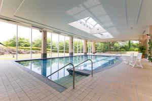 a large swimming pool in a building with windows at Hotel Mt. Fuji in Yamanakako