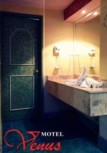 Auto Hotel Venus في خالابا: حمام مع حوض ومرآة وبجعة