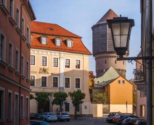 a city street with buildings and a water tower at ApartOne Palais-Apartments in Bautzen