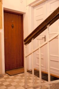 a hallway with a wooden door and stairs at Apartament Parkowy in Sandomierz