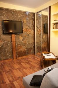 a room with a stone wall with a flat screen tv at Apartament Parkowy in Sandomierz