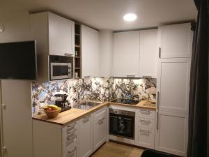 una cocina con armarios blancos y electrodomésticos blancos en Studiohuoneisto Lohjan keskusta 2, en Lohja