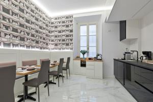 eine Küche mit einem Tisch, Stühlen und einer Theke in der Unterkunft Cavour Suites Guest House in Rom