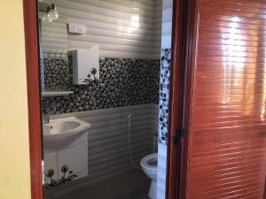 a bathroom with a sink and a toilet at Aashsweet Villa in Calodyne +5 photos