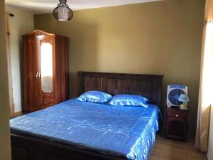 a bedroom with a bed with a blue comforter at Aashsweet Villa in Calodyne