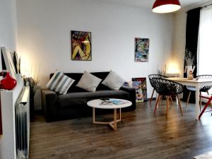 uma sala de estar com um sofá preto e uma mesa em Apartment 18 em Velingrad