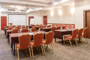 una sala de conferencias con mesas, sillas y una pizarra en Smart Hotel Bishkek, en Bishkek