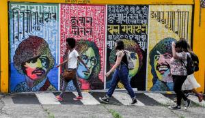 a group of people walking past a wall with graffiti at Vila Rock Hostel - próximo Allianz Parque, Vila Madalena, Av Paulista, Hospital das Clínicas INCOR FMUSP in São Paulo