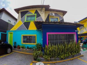 a colorful house in a parking lot at Vila Rock Hostel - próximo Allianz Parque, Vila Madalena, Av Paulista, Hospital das Clínicas INCOR FMUSP in São Paulo