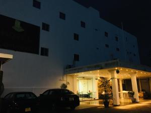 un edificio con coches aparcados delante de él por la noche en Hotel Lovusiyah, en Jaffna