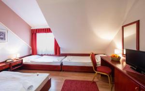 
a hotel room with two beds and a television at B&B Garestin in Varaždin
