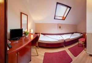 a bedroom with a bed and a desk with a computer at B&B Garestin in Varaždin