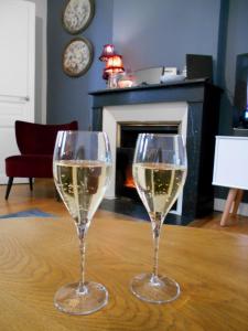 zwei Gläser Weißwein auf dem Tisch in der Unterkunft Coeur du Boulingrin in Reims