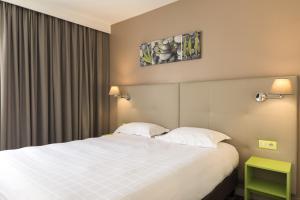 Postel nebo postele na pokoji v ubytování BRIT HOTEL Confort Le Limouzi TULLE