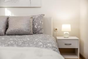 a bedroom with a bed with a lamp on a night stand at Apartman Javor in Otočac