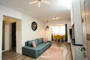 uma sala de estar com um sofá e uma sala de jantar em Briana Luxury Apartment em Cluj-Napoca
