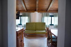 a living room with a green chair and some windows at Agriturismo I Vigneti in Olmedo