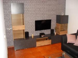 a living room with a flat screen tv on a brick wall at Fam Stana in Wienrode