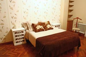 ein Schlafzimmer mit einem Bett und zwei Nachttischen und einem Bett sidx sidx sidx in der Unterkunft Cruxa Apartments garaje incluido in Santiago de Compostela