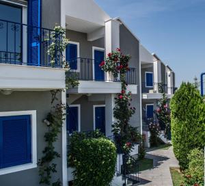 a row of apartment buildings with flowers on balconies at Limni Hotel in Fanari +7 photos