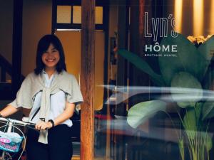 a woman standing in front of a store window at Yu Cafe Hostel in Songkhla
