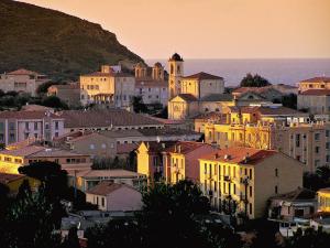 un grupo de edificios en una ciudad al atardecer en Appartement L'Ile-Rousse en LʼÎle-Rousse