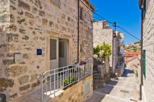 a building with a balcony in an alley at St. Stephen's Square Apartment in Hvar