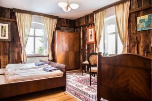 a bedroom with a bed in a room with wooden walls at Art Pension in Przecznica