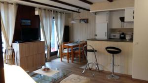 a living room with a kitchen and a table with chairs at Appt 6-8 pers Torgon Portes du Soleil in Vionnaz