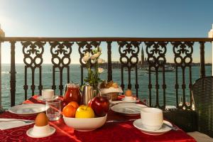 una mesa con fruta y huevos en la parte superior de un balcón en A Tribute To Music Residenza, en Venecia