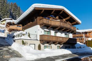 un edificio con la neve sul lato di Villa Mountainview - Kirchberg bei Kitzbühel, Sauna, Kamin, nicht weit zu den Skiliften a Kirchberg in Tirol