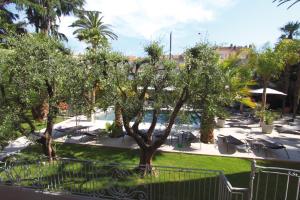 - une vue sur un complexe avec une piscine et des arbres dans l'établissement GOLDEN TULIP CANNES HOTEL de PARIS, à Cannes