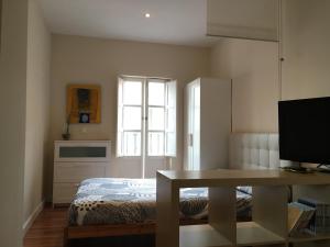 1 dormitorio con cama, mesa y ventana en Vidrio Apartment, en Sevilla