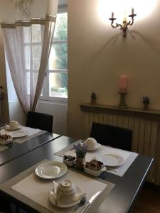 a dining room table with plates of food on it at Hotel du Centre in Pierrelatte +13 photos