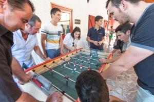 een groep mensen die rond een pooltafel staan bij Hotel du Col d'Osquich in Musculdy